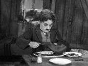 Charlie Chaplin carving up a boot in The Gold Rush